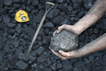 Hand holding lump of coal